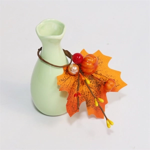 Close-up of ceramic napkin ring with autumn maple leaf, pumpkin and berry details
