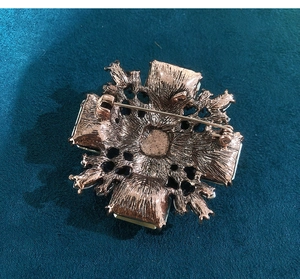 Detailed back view of vintage rose gold brooch with safety clasp and hollow texture