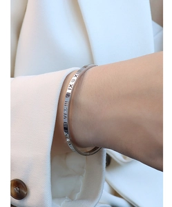 Detail showing roman numerals and inlaid zircons on a silver-tone titanium steel bangle
