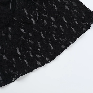 Makroaufnahme von aufwendigem floralem Spitzenmuster auf einem schwarzen Camisole-Top