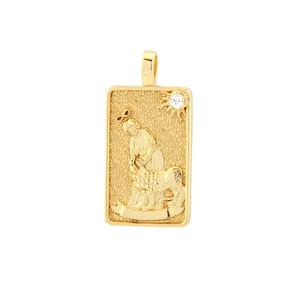 Macro shot of gold-plated tarot card pendant featuring detailed lion and figure relief