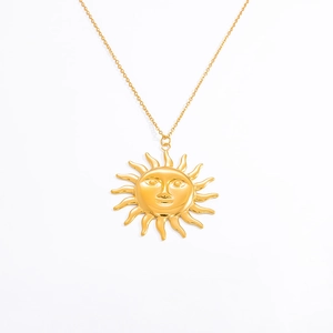 Macro detail of sun pendant necklace in 18k gold finish with a minimalist face design