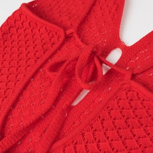 Détail du tissu en maille ajourée rouge avec texture complexe et cordon de serrage lacé
