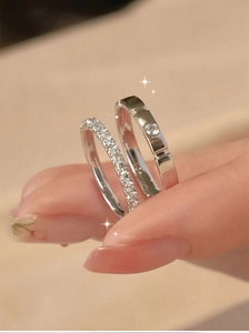 Macro detail of silver couple rings with pavé diamonds and a minimalist solitaire band