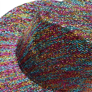 Close-up of vibrant pink, yellow and blue metallic woven texture on a fashion cowboy hat