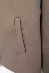 Close-up of the welt pocket design and high-quality wool fabric texture on a brown jacket