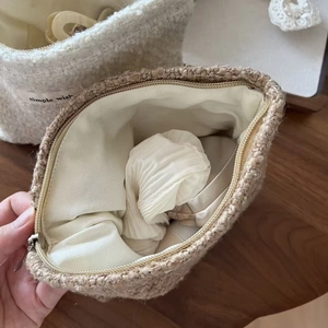 Detail of soft wool makeup bag showing spacious interior with lining and zipper closure