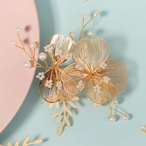 Macro view of gold bridal hairpins with pearl accents and delicate hollow flowers