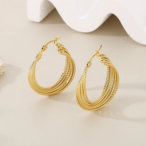 Detailed view of twisted gold-plated stainless steel hoop earrings on a white stand