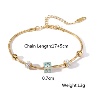 Macro detail of gold evil eye bracelet with blue enamel and sparkling crystal beads