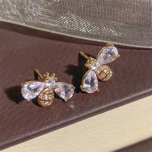 Macro detail of bee earring with cubic zirconia wings and micro-paved gold finish