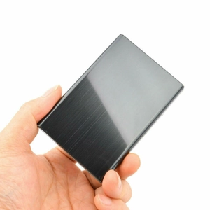 Detailed close-up of a hand holding a black brushed metal business card holder for scale