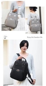 Close-up of minimalist grey and black multi-pocket nylon backpacks for maternity travel