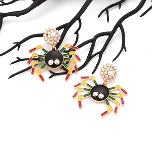 Gothic spider drop earrings with pearls and colorful enamel legs on a dark branch