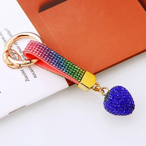 Detailed macro view of rainbow rhinestone leather strap and blue strawberry pendant charm