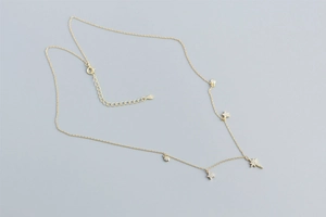Detail of gold S925 silver necklace with sparkling star and zircon pendants