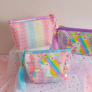 Rainbow glitter unicorn PVC makeup bags with plush charms on a starry mesh background