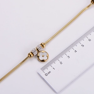 Detail view of gold clover bracelet with white shell inlay and 1.5cm width measurement