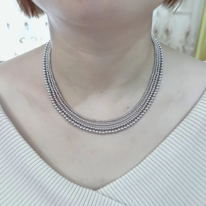 Detail of multi-layer stainless steel beaded necklace with silver metallic luster