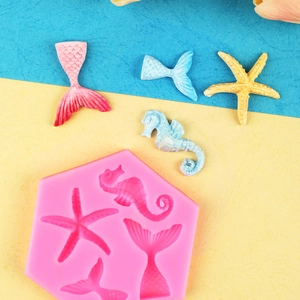 Pink silicone mold featuring starfish, seahorse, and mermaid tail for ocean cake decor