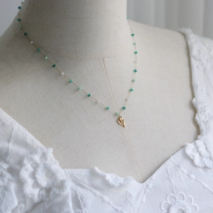 Vintage 18K gold-plated tulip flower necklace with green stones on a white model