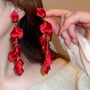 Close-up of red rose petal tassel drop earrings worn by a model for an elegant look