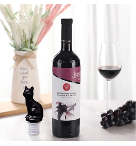 Close-up of black cat head wine bottle stopper with silicone seal on white table