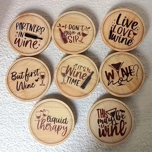 Set of 8 round bamboo wine coasters with engraved quotes on white background