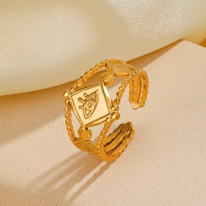 Adjustable gold stainless steel geometric ring featuring an evil eye motif on a textured stand