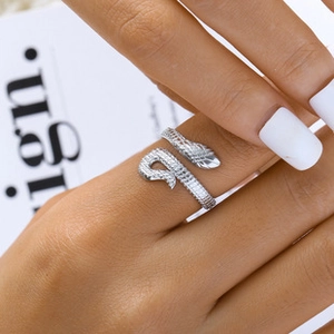 Close-up of silver snake-shaped open ring with detailed scale texture on model's finger