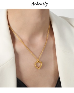Détail du collier pendentif cœur en or 18 carats avec design évidé porté par un modèle