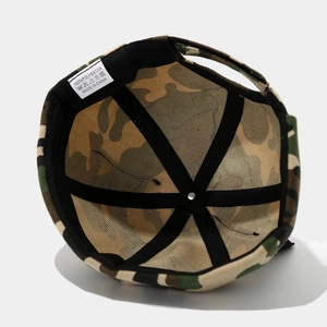 Detail view of the camouflage brimless hat interior showing polyester fabric and labels