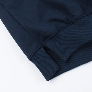 Detail of navy blue knit sweatshirt hem featuring side slit and ribbed texture finish