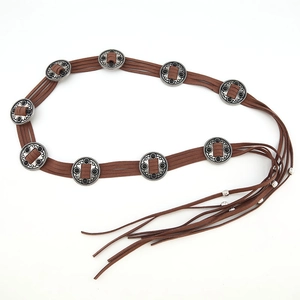 Detail of bohemian brown suede belt with vintage silver medallions and tassel fringe