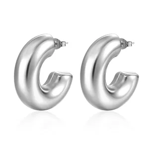 Close-up of chunky silver C-shape earrings with a high-polished mirror finish and butterfly backs