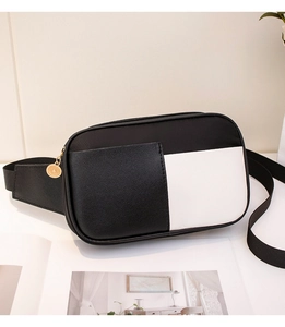 Détail du sac de poitrine contrasté en cuir noir avec fermeture éclair dorée chic