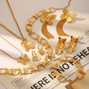 Flat lay of a gold butterfly jewelry set featuring necklaces, earrings, and a bracelet