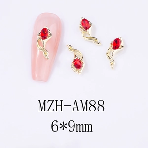 Macro shot of 6x9mm gold alloy nail charms with red marquise rhinestones and sample application