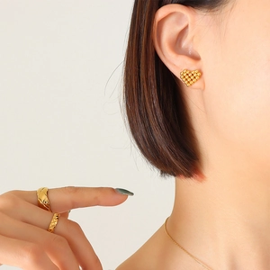 Elegante set di gioielli in titanio dorato con orecchini a cuore e anello su modella