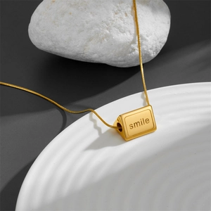 Golden titanium steel prism necklace with smile engraving on a circular snake chain