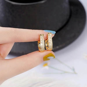 Close-up of gold U-shaped hoop earrings with micro-paved cubic zirconia and hollow patterns
