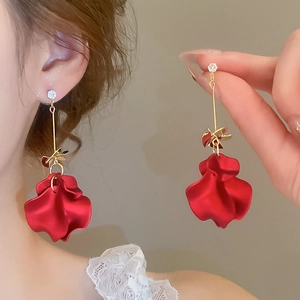 Detail of red petal tassel earrings with gold accents and zircon studs for women