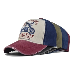 Stacked vintage distressed baseball caps showing retro motorcycle print and worn edge details