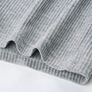 Nahaufnahme von grauem Rippstrick-Stoff mit detaillierten Nähten und weicher Textur