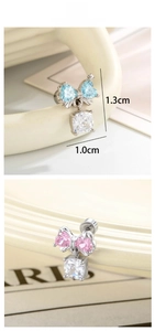 Detail of bow-shaped stud earrings with square zircon pendant in blue and pink colors