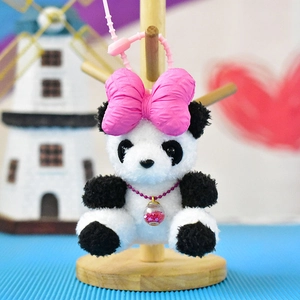 Detailed macro view of a cute plush panda keychain with a vibrant pink bow accessory
