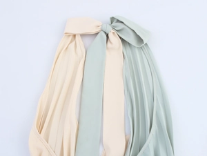 Detail of cross halter neckline with beige and green pleated chiffon fabric textures
