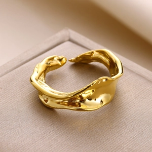 Detail of gold open ring featuring unique irregular lava texture and metallic finish