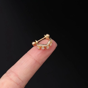 Macro shot of 20G gold crown earring with cubic zirconia and screw ball on fingertip