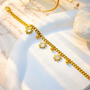 Gold Cuban chain bracelet featuring shell sunflower charms on white ceramic pedestal